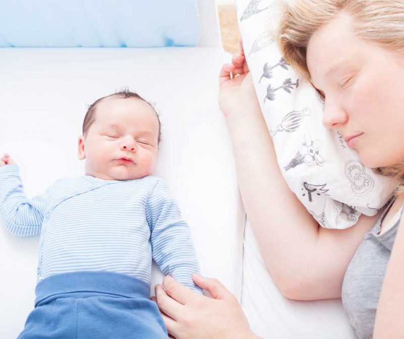 Une maman endormie avec son bébé dans un lit | Dr François Auger Chiropraticien - Chiropratique Québec, Chiro Nord, Stoneham, NDL, Lac Saint-Charles