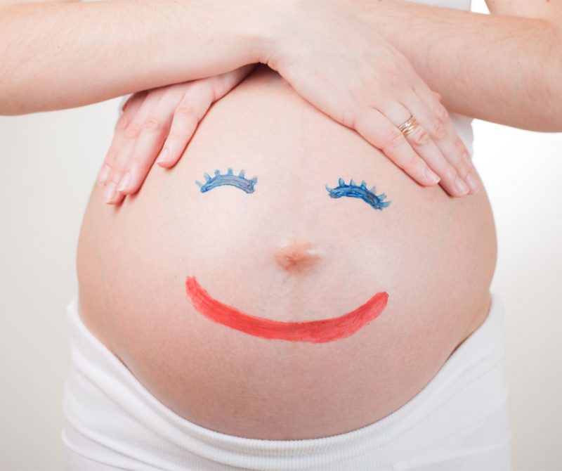 Un ventre du femme enceinte avec un visage souriant | Dr François Auger Chiropraticien - Chiropratique Québec, Chiro Nord, Stoneham, NDL, Lac Saint-Charles