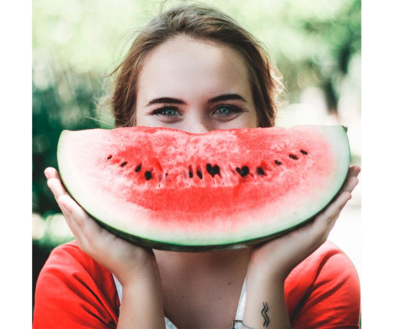 Une femme heureuse où son sourire est présenté avec un melon d'eau | Dr François Auger Chiropraticien - Chiropratique Québec, Chiro Nord, Stoneham, NDL, Lac Saint-Charles