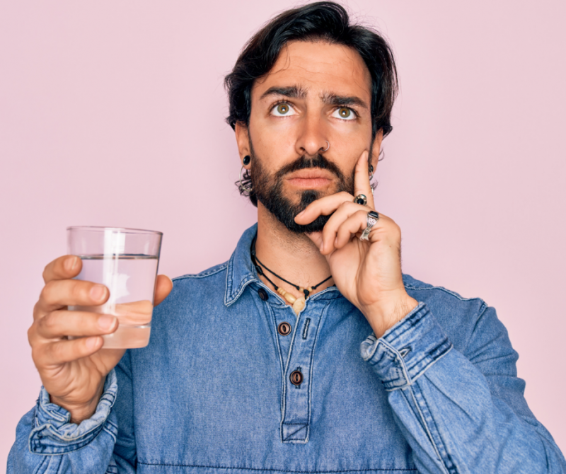 Homme qui réfléchit pour savoir si il doit boire ou pas son verre d'eau | Dr François Auger Chiropraticien - Chiropratique Québec, Chiro Nord, Stoneham, NDL, Lac Saint-Charles