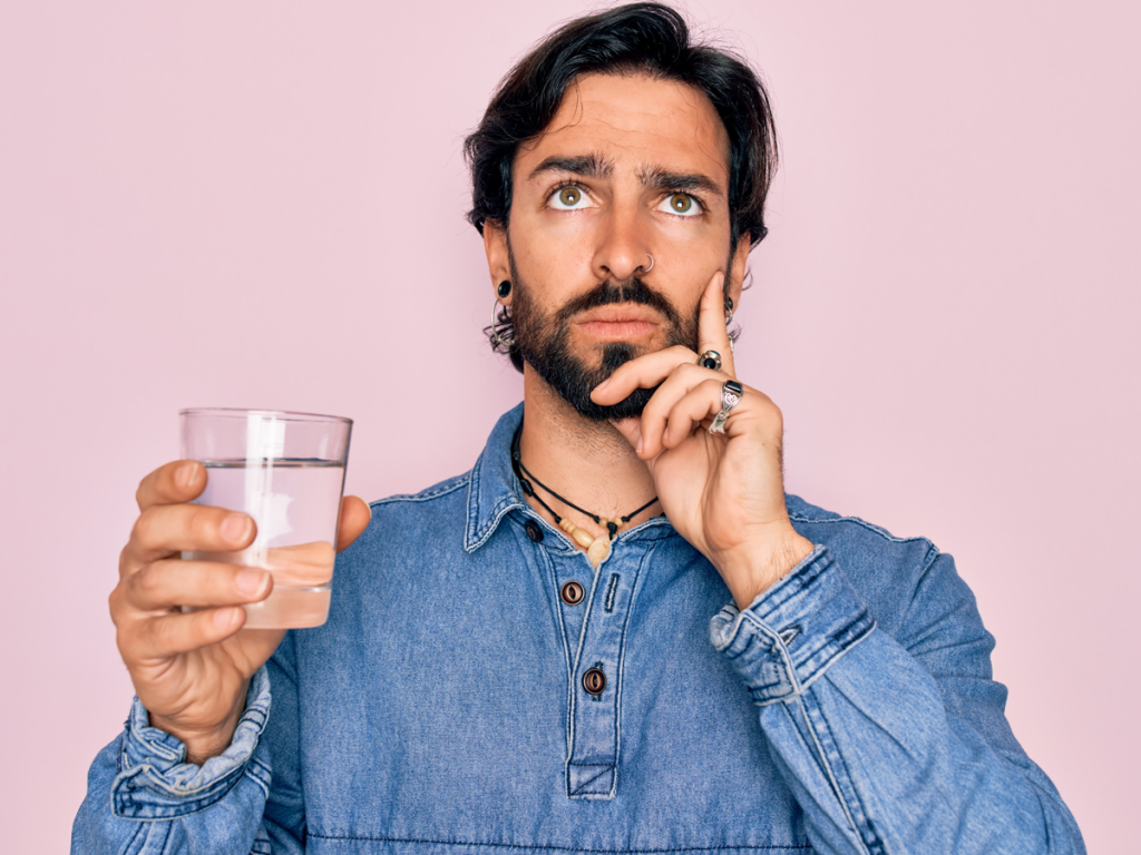 Homme qui réfléchit pour savoir si il doit boire ou pas son verre d'eau | Dr François Auger Chiropraticien - Chiropratique Québec, Chiro Nord, Stoneham, NDL, Lac Saint-Charles