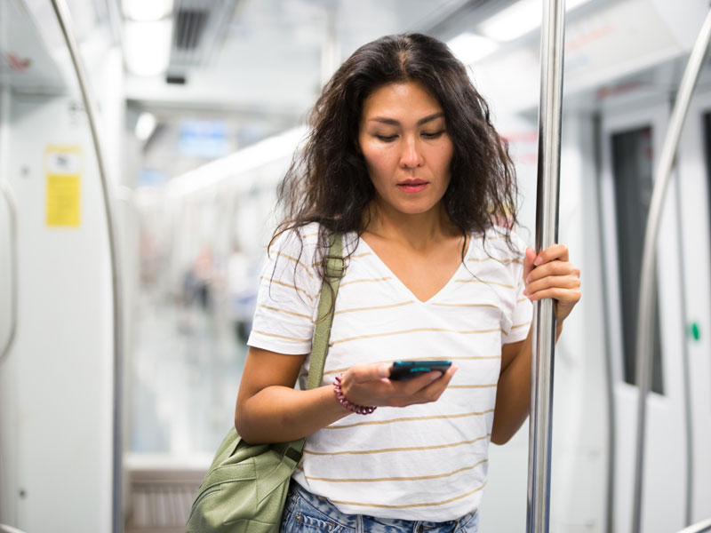 Femme qui regarde son téléphone dans le métro ou dans l'autobus | Dr François Auger Chiropraticien - Chiropratique Québec, Chiro Nord, Stoneham, NDL, Lac Saint-Charles